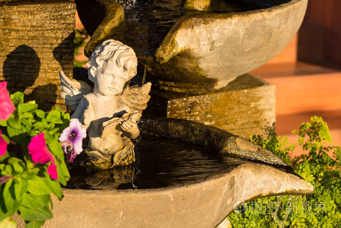 古老的白色天使丘比特雕塑坐水喷泉