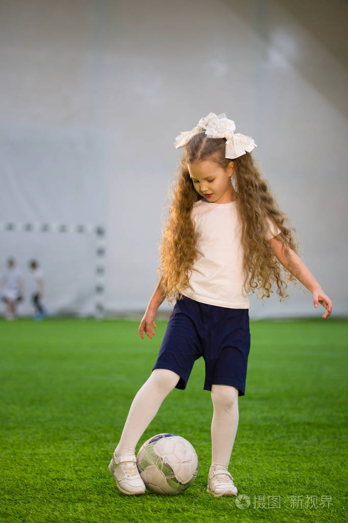 一个小女孩在足球场上踢皮球比赛