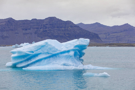 冰岛东南部的Jokulsarlon海滩钻石海滩上有黑色沙滩的冰崖。 太阳升起时的冰