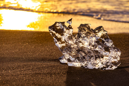 冰岛东南部的Jokulsarlon海滩钻石海滩有一个黑色沙滩的冰崖。太阳升起时的冰