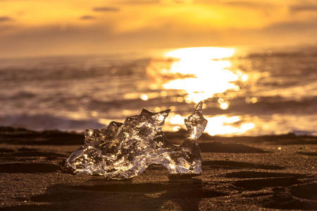 冰岛东南部的Jokulsarlon海滩钻石海滩有一个黑色沙滩的冰崖。太阳升起时的冰