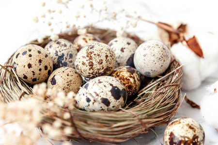 复活节装饰与蛋在巢和棉花在白色大理石背景。复活节的概念。平躺顶视复印空间..春季贺卡
