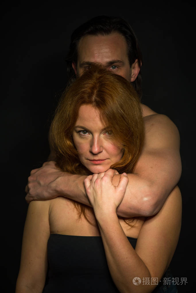 在安全方面. 穿着黑色露肩连衣裙的讨人喜欢的女人的肖像,表达了平静,