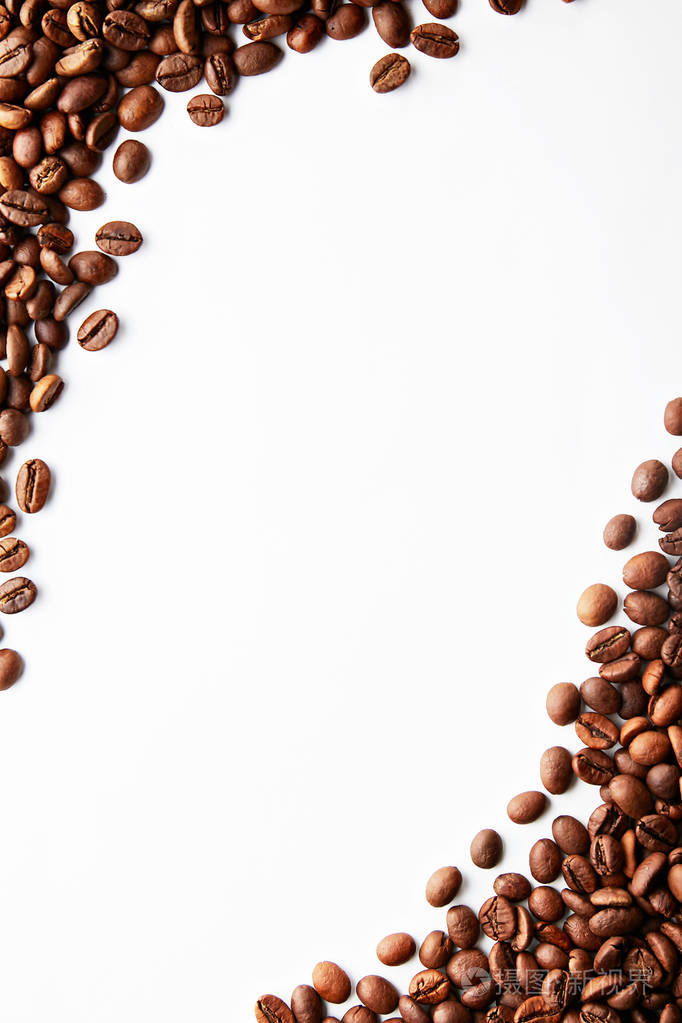 烤棕色咖啡豆散落在白色的桌子上,有很大的文本复制空间. 平躺构图.