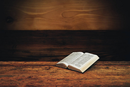 圣经在一个旧的木制桌子背景上。