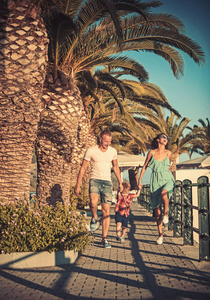快乐家庭的暑假。母亲和父亲带着儿子在海边散步。孩子与父亲和母亲。家庭旅行与孩子在母亲或父亲天。爱和信任作为家庭价值