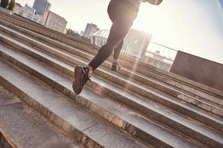 在早晨在城市里锻炼时, 在楼上慢跑运动的运动员的视线中减少视线照片