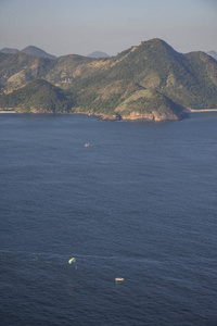 从巴西里约热内卢的糖卷山上可以看到背面有山的帆船在海上航行