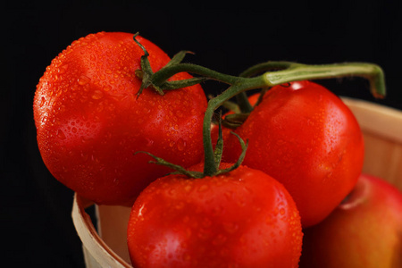 三个成熟的西红柿在一个篮子里