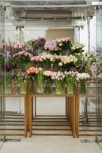 玫瑰郁金香和牡丹放在玻璃桌上的花瓶里