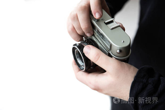 一位男性摄影师拍摄镜头的中间部分,同时手持一台35毫米老式相机,在