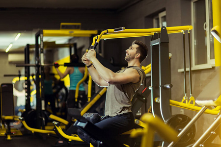 概念力量健康生活方式运动力量强壮的肌肉男在健身房锻炼在训练机上牵引