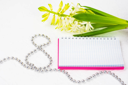 s Day. White spring flowers, hyacinth. Notebook in a pink cover