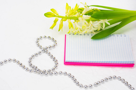 s Day. White spring flowers, hyacinth. Notebook in a pink cover