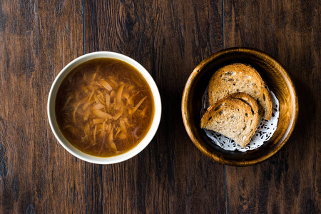 黑色木制表面有面包的法国洋葱汤。 传统的有机食品。