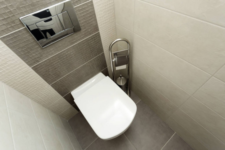 白色马桶在现代浴室与纸架和马桶刷。