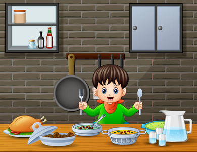 快乐的小男孩拿着勺子和叉子在桌子旁吃东西