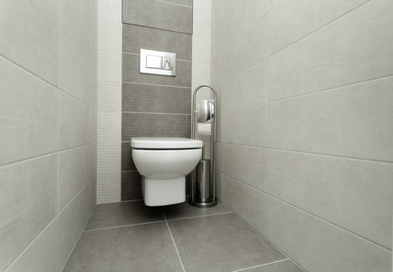 白色马桶在现代浴室与纸架和马桶刷。