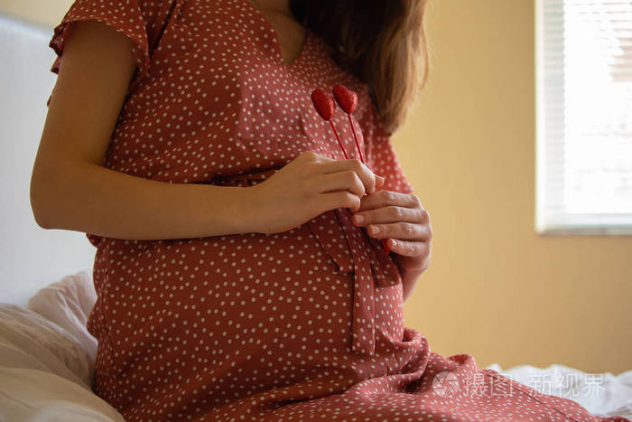 无脸侧视镜头孕妇抚摸腹部与爱,同时休息在一个坏. 闭上大怀孕的肚子.