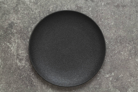 石桌上的黑色盘子餐具。 表格设置。