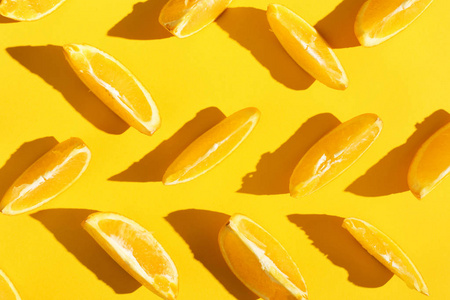 橘子切片在黄色背景明亮的图案壁纸上。
