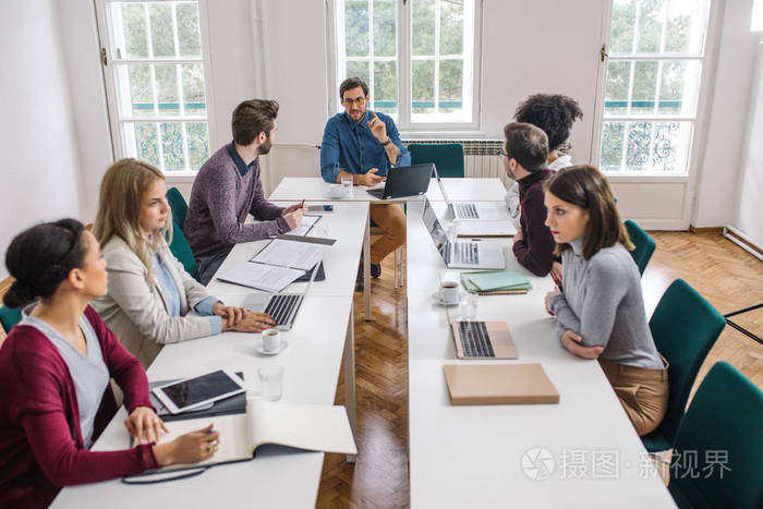 一群年轻人在现代办公场所开会.照片-正版商用图片18w6sn-摄图新视界