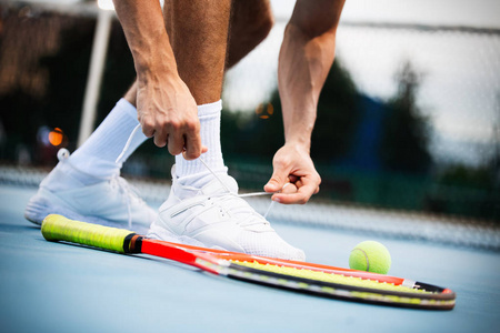 网球运动员准备在比赛中系鞋带