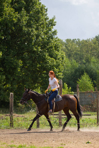 一个红头发的女人骑着皮带骑马