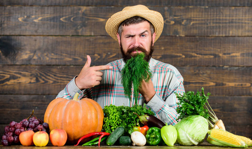 留胡子的人以他收获的蔬菜为荣, 以木制为背景。与有机蔬菜。刚从花园出来杂货店概念。买新鲜的国产蔬菜。优质蔬菜