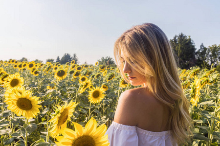 欧美气质女阳光明媚的夏日,美丽的年轻白种人女人在向日葵田里摆姿势.