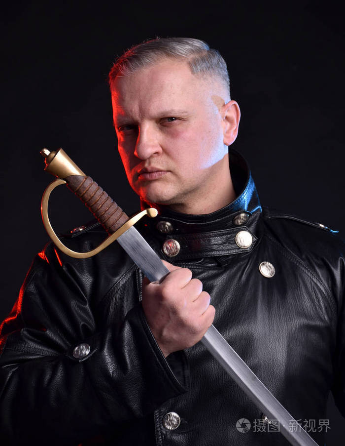 穿着黑色夹克的英俊男子手持黑色背景剑