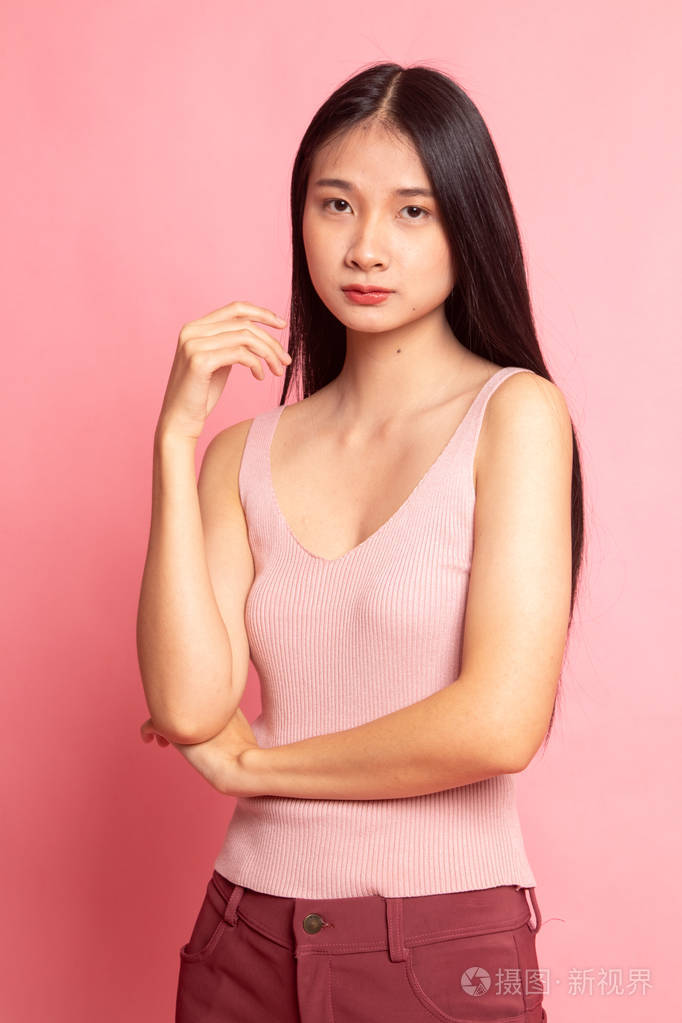 粉红色背景下美丽的年轻亚洲女人的肖像