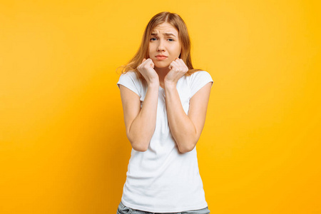 焦躁紧张一个穿着白色t恤的焦躁不安的女孩咬着指甲,表情不安,站在