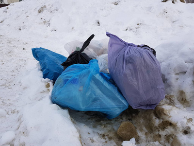 冬天散落在雪地上的垃圾和垃圾袋