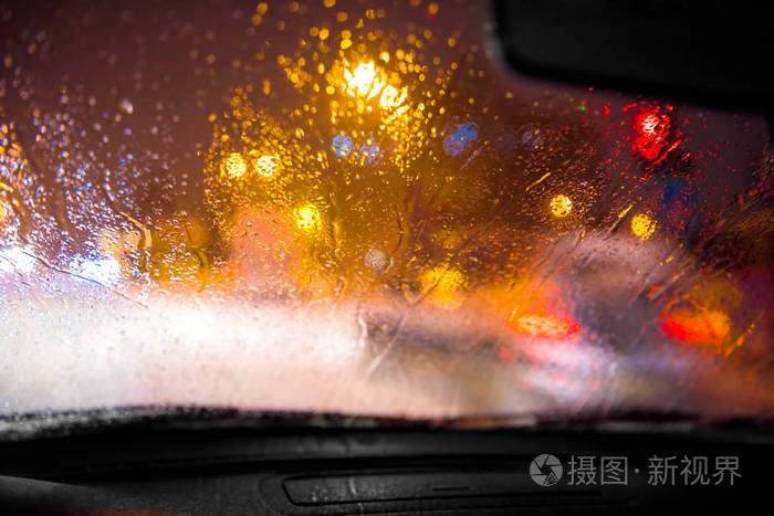 路灯背景模糊的车窗上的雨滴