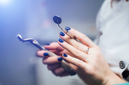 s hands holding dental tools