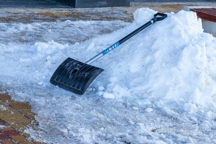 一把黑色铲子和一堆雪.除雪的概念