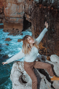 美丽的女人在葡萄牙的卡塞西的岩石悬崖上摆姿势