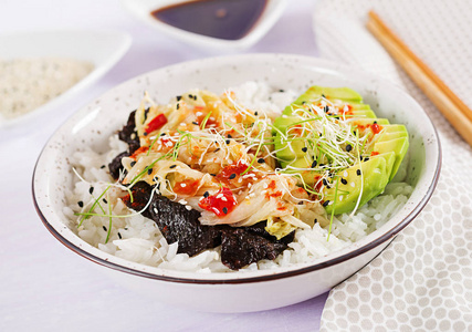 纯素沙拉与米饭腌制泡菜，卷心菜，鳄梨，诺里和芝麻在碗里。 寿司食品杂交趋势。 间接费用