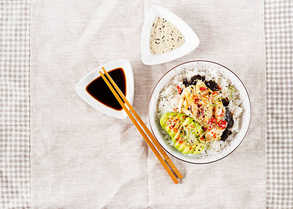 纯素沙拉与米饭腌制泡菜，卷心菜，鳄梨，诺里和芝麻在碗里。 寿司食品杂交趋势。 俯视平面铺设。