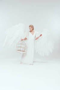 美丽的女人，穿着天使的服装，有翅膀，抱着鸟笼，与世隔绝的白色
