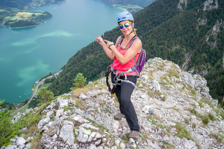 在一个温暖的夏天，女子登山者在德兰森和蒙德西奥地利上空指着下面的湖，完成了一条经过费拉塔的路线。