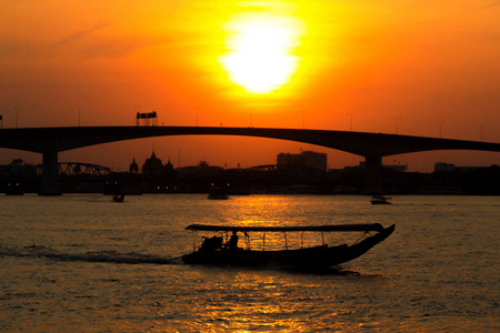 泰国曼谷，朝佛拉亚河，夕阳的微光，河上的船，桥背景