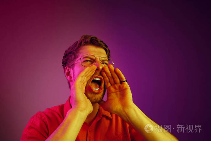 孤立的粉红色年轻的休闲男子在工作室大喊大叫