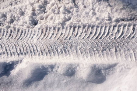 冬季雪道上的车辆和拖拉机轮胎胎面印记，靠近顶部视图。 一条水平线，顶部和底部有复制空间。