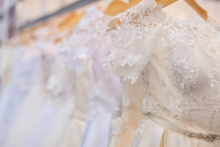 优雅的婚纱挂在婚礼沙龙的衣架上。