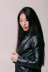 亚洲模特在黑色夹克摆在工作室