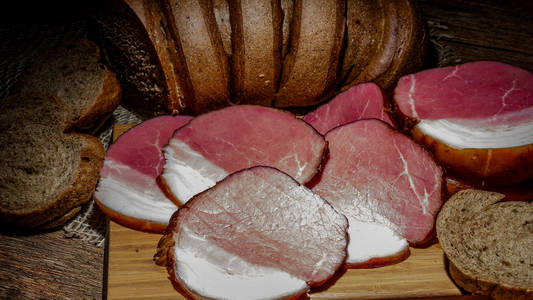 木制背景的熏肉和麸皮面包