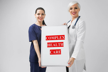 医生和护士拿着海报以题字复杂医疗查出在白色背景