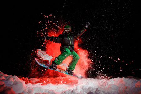 活跃的女滑雪者穿着绿色运动服在雪下跳跃
